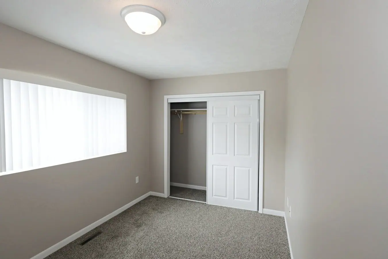 Bedroom with a large double-door closet and a wide window
